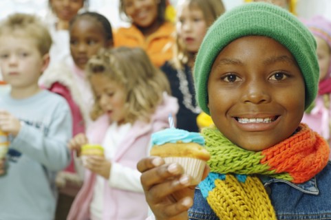 African girl holding cupcake