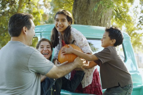 Multi-ethnic family holding pumpkin