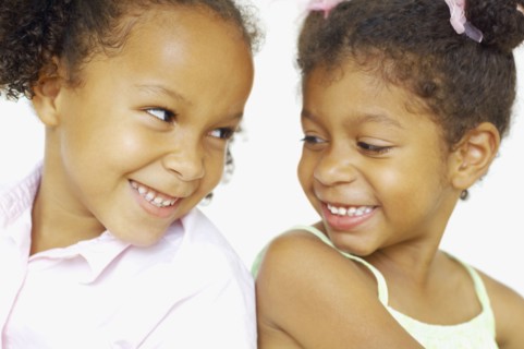 Close up of multi-ethnic girls smiling at each other