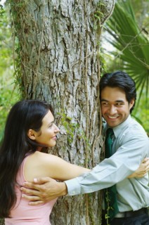 Hispanic couple hugging tree