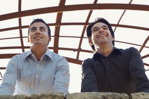 Hispanic businessmen leaning on wall