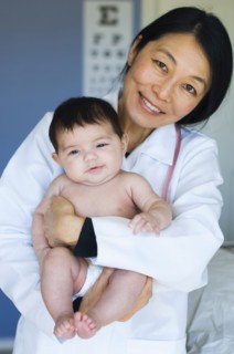 Doctor holding baby in office