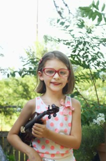 Hispanic girl holding violin outdoors