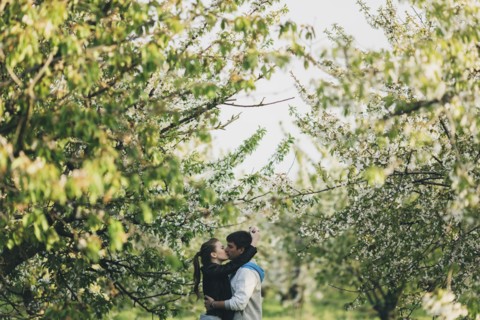 Caucasian couple kissing near trees