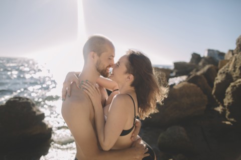 Caucasian couple hugging on beach
