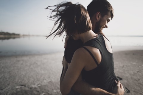 Caucasian couple hugging on beach
