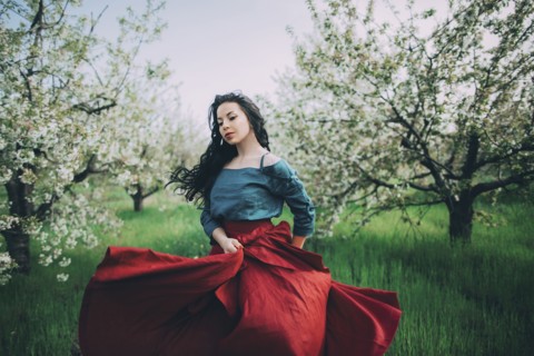 Caucasian woman dancing near flowering trees