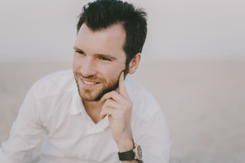 Caucasian man sitting on beach