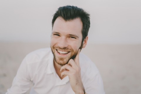 Caucasian man sitting on beach