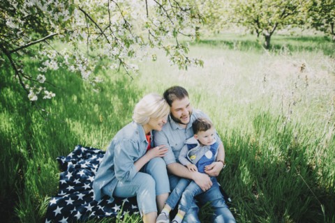 Caucasian multi-generation family sitting on blanket in grass
