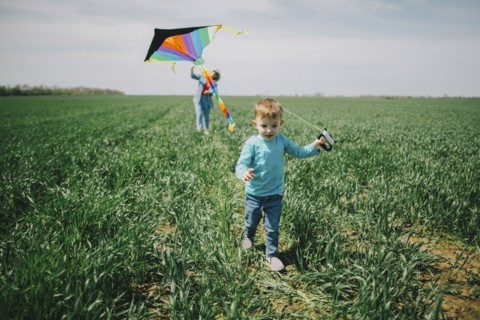 Caucasian boy and grandmother flying kite in field