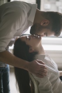 Caucasian man kissing woman in chair