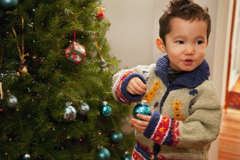 Mixed race boy decorating Christmas tree