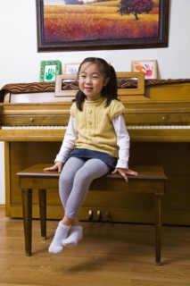Korean girl sitting on piano bench