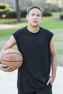 Mixed race boy holding basketball