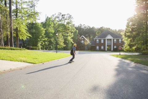 Caucasian boy skateboarding on road