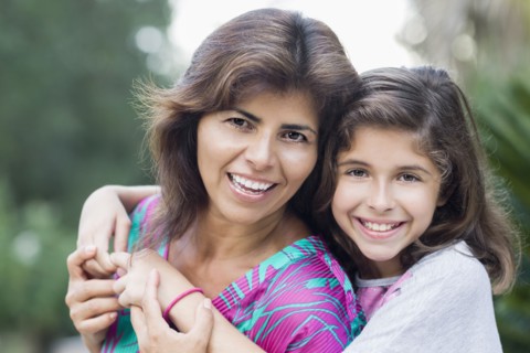 Smiling Hispanic mother and daughter
