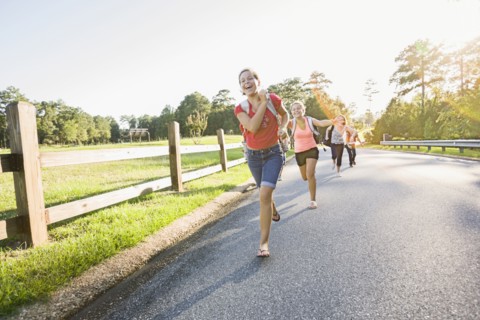 Caucasian girls running on road