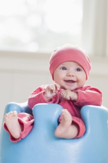 Smiling Caucasian baby sitting in chair