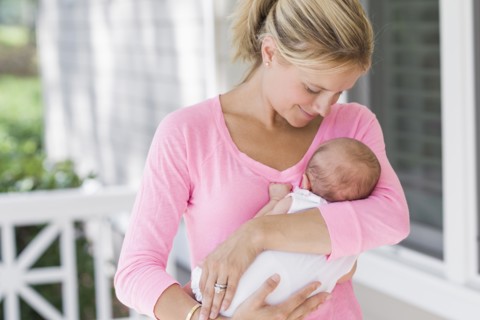 Caucasian mother holding baby on porch