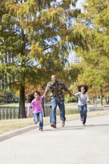 Father and daughters playing in park