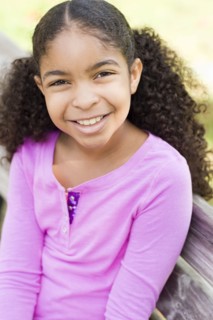 Cape Verdean girl smiling on park bench