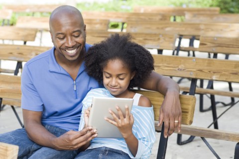 Father and daughter using tablet computer