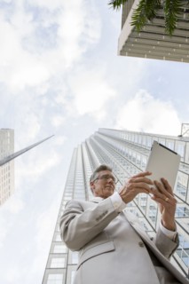 Caucasian businessman with tablet computer on city street