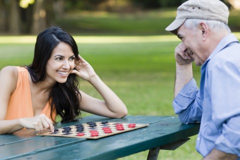 Hispanic father and daughter playing checkers