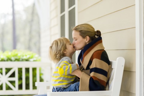Caucasian mother and son kissing