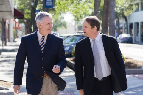 Caucasian businessmen walking on city street
