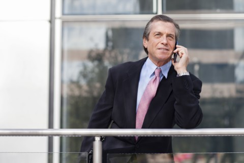 Caucasian businessman on cell phone on balcony