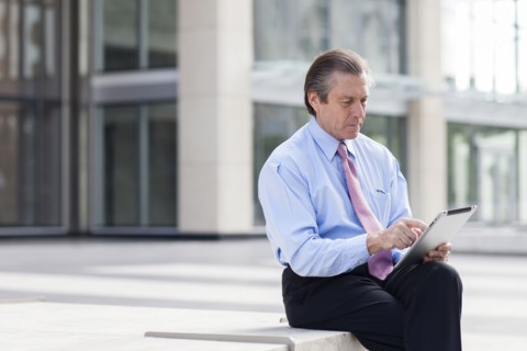 Caucasian businessman using digital tablet in courtyard