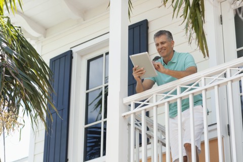 Caucasian man using digital tablet on balcony