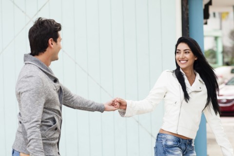 Hispanic couple holding hands outdoors