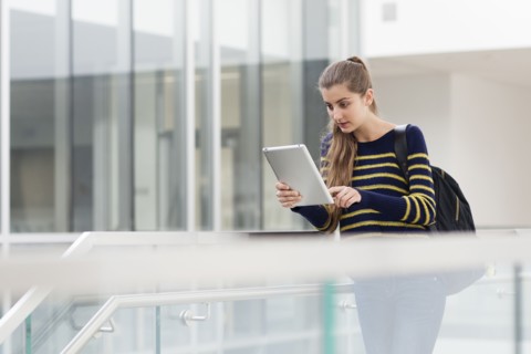 Caucasian student using digital tablet on campus