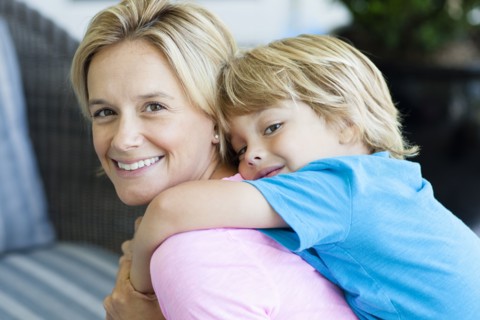 Caucasian mother carrying son piggyback