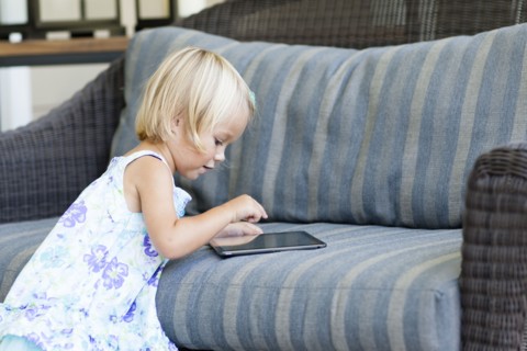 Caucasian girl using digital tablet on sofa