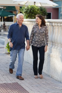 Older Caucasian couple holding hands on sidewalk