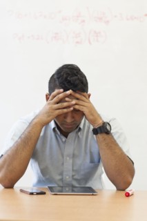 Frustrated Asian businessman with digital tablet and cell phone