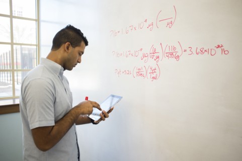 Asian businessman using digital tablet at whiteboard