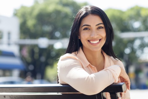 Hispanic woman smiling on bench