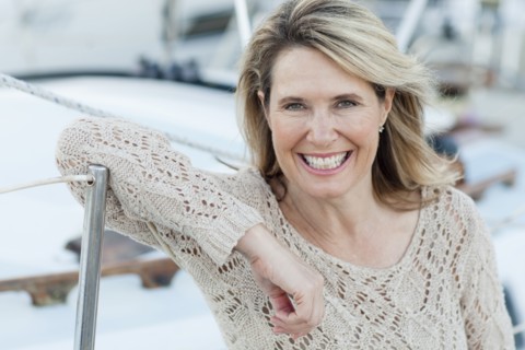 Caucasian woman leaning on boat in harbor