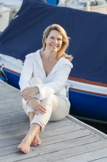 Caucasian woman sitting on deck in harbor