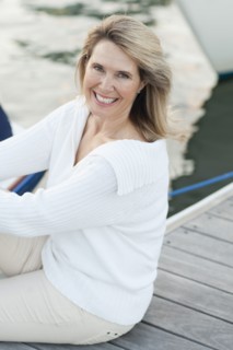 Smiling Caucasian sitting on deck in harbor