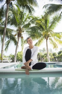 Smiling woman dipping toes in swimming pool