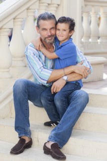 Caucasian father and son hugging on front stoop