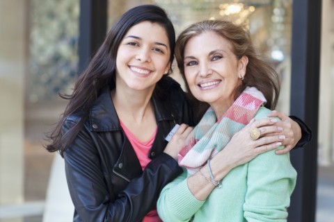 Mother and daughter hugging outside store