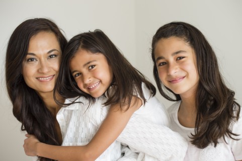 Close up of mother and daughters hugging