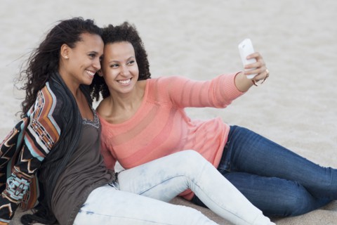 Women taking selfies on beach